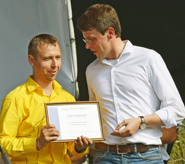 Генеральний директор «Контіненталу» Георг фон Нолкен (праворуч) вручає сертифікати на придбання 400 ящиків для збирання врожаю голові кооперативу «Ягідний рай» Михайлові Барвінку